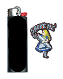 Front view of Smokin' Buddies "Smoke Me" Alice Pin next to lighter.