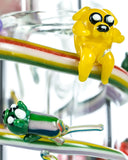 Close up view of Characters on Empire Glassworks Land of Ooo Mini Water Pipe showing characters from Adventure Time sliding down a rainbow.
